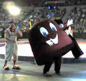 A clown and a large fez-shaped Shriner mascot parade around the
arena.